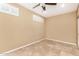 A minimalist bedroom with neutral walls, tiled floors and a ceiling fan at 20515 N 271St Ave, Buckeye, AZ 85396