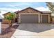 Exterior view of a two-car garage with stone accents and well-maintained driveway at 20515 N 271St Ave, Buckeye, AZ 85396