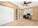 A bright office featuring built-in shelving, double closets, tile flooring, and a ceiling fan at 20515 N 271St Ave, Buckeye, AZ 85396