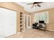 Spacious office with a ceiling fan, built-in shelving, and large desk with a computer setup at 20515 N 271St Ave, Buckeye, AZ 85396