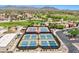 Aerial view of community tennis and pickleball courts with mountain views in the background at 22419 W La Pasada Blvd, Buckeye, AZ 85326