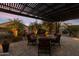 Backyard patio with a firepit surrounded by an outdoor seating area and lush, mature landscaping at 22419 W La Pasada Blvd, Buckeye, AZ 85326