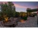 This landscaped yard with a patio area includes comfortable seating and ambient outdoor lighting at 22419 W La Pasada Blvd, Buckeye, AZ 85326