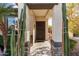 Inviting entryway featuring a decorative security door, desert landscaping, and a covered porch at 22419 W La Pasada Blvd, Buckeye, AZ 85326