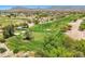An aerial view of a vibrant green golf course with sand traps and mature trees at 22419 W La Pasada Blvd, Buckeye, AZ 85326