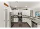 Modern kitchen featuring white cabinetry, stainless steel appliances, and granite countertops with tile backsplash at 22419 W La Pasada Blvd, Buckeye, AZ 85326
