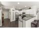Modern kitchen with white cabinets, stainless steel appliances, granite countertops, and a breakfast bar at 22419 W La Pasada Blvd, Buckeye, AZ 85326