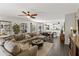 Bright, open-concept living room featuring a large sectional sofa and view into the dining area and kitchen at 22419 W La Pasada Blvd, Buckeye, AZ 85326