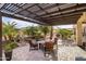 Outdoor patio area with pavers, wooden pergola, mature landscaping, and outdoor seating area at 22419 W La Pasada Blvd, Buckeye, AZ 85326