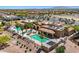 A community pool area with people swimming surrounded by lounge chairs, palms and well-maintained landscaping at 22419 W La Pasada Blvd, Buckeye, AZ 85326