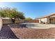 Large backyard featuring mature trees, desert landscaping, and concrete patio at 22727 W Papago St, Buckeye, AZ 85326