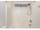 Clean bathtub with a shower featuring white tiling and a window above at 22727 W Papago St, Buckeye, AZ 85326