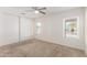 Bedroom featuring a ceiling fan, carpeted floors, and two windows for natural light at 22727 W Papago St, Buckeye, AZ 85326