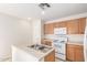 Well-lit kitchen featuring wood cabinetry and white appliances at 22727 W Papago St, Buckeye, AZ 85326