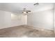 Spacious living room featuring neutral carpeting, light walls, and a ceiling fan at 22727 W Papago St, Buckeye, AZ 85326