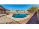 Backyard pool area with a rock feature, surrounded by desert landscaping and wrought iron fence at 22727 W Papago St, Buckeye, AZ 85326