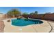Backyard pool featuring a rock waterfall, surrounded by desert landscaping, offering a serene outdoor space at 22727 W Papago St, Buckeye, AZ 85326