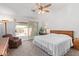 Bright main bedroom featuring carpet, ceiling fan, backyard access, and an accent chair at 24832 S Boxwood Dr, Sun Lakes, AZ 85248
