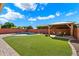 An artificial grass backyard with a pool and covered patio, perfect for outdoor living at 2517 W Balao Dr, Phoenix, AZ 85085