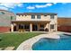 Spacious backyard featuring a well-maintained lawn, a pool with water features, and outdoor dining area at 2517 W Balao Dr, Phoenix, AZ 85085