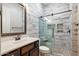 Bathroom featuring a glass shower with pebble-tiled floor and a wood-style vanity at 2517 W Balao Dr, Phoenix, AZ 85085