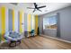 Bright bedroom with a unique color-blocked wall, a sleek ceiling fan, and a window offering a view at 2517 W Balao Dr, Phoenix, AZ 85085