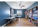 Spacious office with blue walls, a ceiling fan, a large desk, and ample shelving for storage at 2517 W Balao Dr, Phoenix, AZ 85085