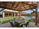 Outdoor patio with a covered seating area and fire pit, overlooking a well-maintained lawn and pool at 2517 W Balao Dr, Phoenix, AZ 85085