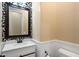 Stylish powder room features a decorative mirror, a modern sink, and white wainscoting at 2517 W Balao Dr, Phoenix, AZ 85085