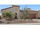 Close up view of front exterior showcasing xeriscaping, mature plants, and attached garage at 29534 N 128Th Ln, Peoria, AZ 85383