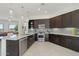Well-lit kitchen with dark wood cabinets, stainless steel appliances, and an eat-in island at 29534 N 128Th Ln, Peoria, AZ 85383