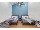 Cozy bedroom with two twin beds, blue accent wall, and ceiling fan at 2629 S Country Club Way, Tempe, AZ 85282