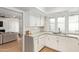 Bright kitchen with white cabinets, marble countertops, and stainless steel sink under window at 2629 S Country Club Way, Tempe, AZ 85282