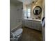 Well-lit bathroom with tile flooring, tub, and vanity with round mirror at 2650 W Union Hills Dr # 272, Phoenix, AZ 85027
