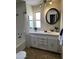 Cozy bathroom featuring a vanity with ample storage, a stylish round mirror, and modern fixtures at 2650 W Union Hills Dr # 272, Phoenix, AZ 85027