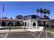 Exterior view of the community clubhouse featuring a tile roof, archways, and well-maintained landscaping at 2650 W Union Hills Dr # 272, Phoenix, AZ 85027