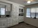 Galley kitchen features white cabinets and laminate flooring at 2650 W Union Hills Dr # 272, Phoenix, AZ 85027
