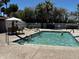 Community pool with clear blue water, surrounded by lounge chairs, umbrellas, and lush landscaping at 2650 W Union Hills Dr # 272, Phoenix, AZ 85027