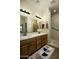 Bathroom featuring double sinks with marble countertops, wood cabinets, and a walk-in shower with a grab bar at 2662 S Springwood Blvd # 341, Mesa, AZ 85209