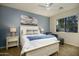 Charming bedroom with a queen-sized bed, soft blue accent wall, and a window view of the neighborhood at 2662 S Springwood Blvd # 341, Mesa, AZ 85209