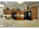 Kitchen with granite countertops, wood cabinets, and modern appliances, with stylish decor atop the cabinets at 2662 S Springwood Blvd # 341, Mesa, AZ 85209