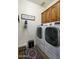 Bright laundry room with side-by-side washer and dryer, overhead storage, and decor at 2662 S Springwood Blvd # 341, Mesa, AZ 85209