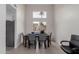 Light and airy dining room with tall ceilings, a large window, and a gray table at 3234 E Marco Polo Rd, Phoenix, AZ 85050