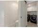 Practical laundry room with modern washer and dryer, storage cabinets, adjacent to a convenient half-bathroom at 3234 E Marco Polo Rd, Phoenix, AZ 85050