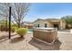 Backyard features a spa, desert landscaping, and lighting with a glimpse of the house at 328 W Dragon Tree Ave, San Tan Valley, AZ 85140