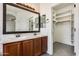 Bathroom showcasing double sinks, a framed mirror, and a walk-in closet at 328 W Dragon Tree Ave, San Tan Valley, AZ 85140