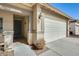 Front entrance featuring a private front porch, desert landscaping, and an attached two-car garage at 328 W Dragon Tree Ave, San Tan Valley, AZ 85140