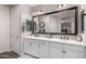 Bright bathroom features double sinks, white cabinets, and a large, framed mirror above at 3522 E Spring Wheat Ln, Gilbert, AZ 85296
