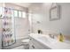Well-lit bathroom features a tub with shower, white vanity, and decorative mirror at 3522 E Spring Wheat Ln, Gilbert, AZ 85296