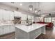 Bright kitchen features white cabinets, a patterned backsplash, and a large island with pendant lighting at 3522 E Spring Wheat Ln, Gilbert, AZ 85296